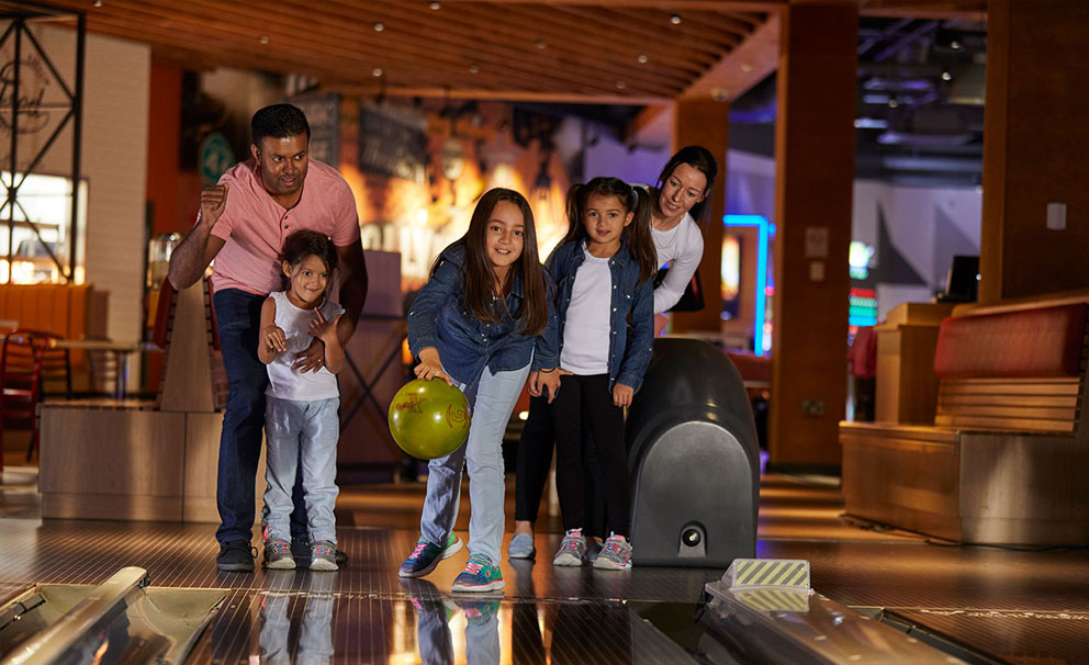 girl bowling with family